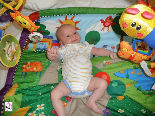 Infant playing on play mat
