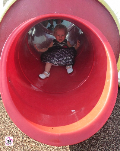 1 year old going down slide in dress
