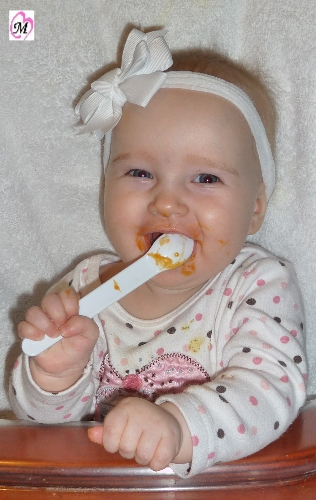Baby feeding self with spoon